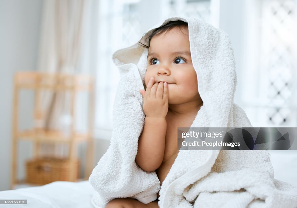 Aufnahme eines entzückenden Babys, das nach dem Baden mit einem Handtuch bedeckt ist