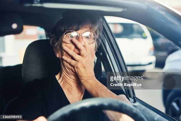 ältere frau bekommt einen bösen schreck im verkehr, als sie ein auto fährt - panic attack stock-fotos und bilder