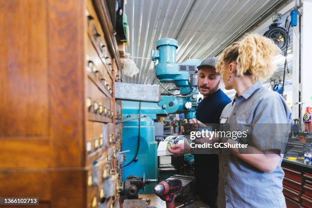 auto mechanics working as team on a repair job - equal pay stockfoto's en -beelden