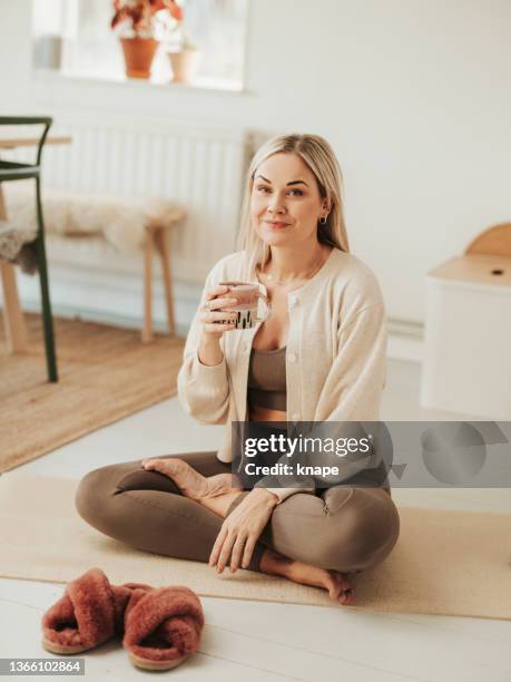 mujer en esterilla de yoga antes / después de practicar con té de café - yogi fotografías e imágenes de stock