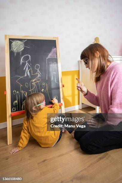 mother scolding her little daughter while playing together at home. - strict parent stock-fotos und bilder