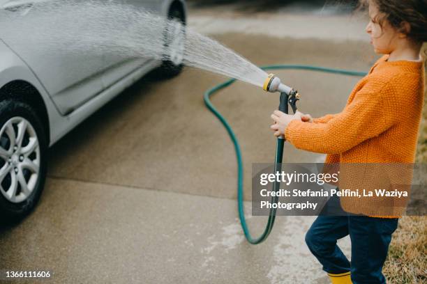 little girl washing her parents' car - car wash stock pictures, royalty-free photos & images