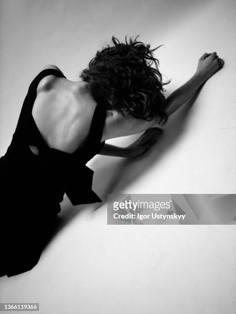 rear view of young slim woman lying on the floor - anorexia nervosa stock pictures, royalty-free photos & images
