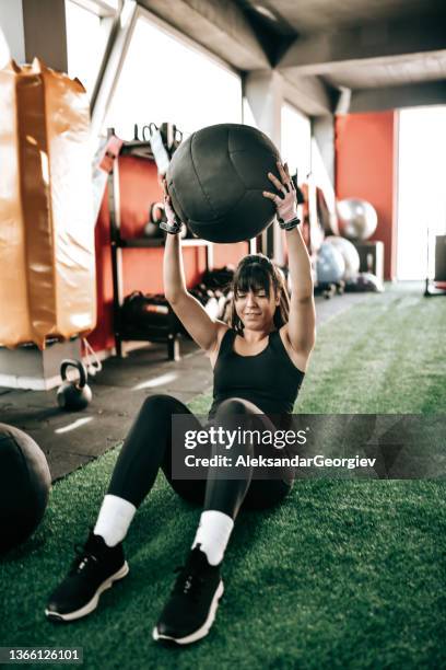 fitness ball sit ups workout for female athlete in gym - medicine ball stock pictures, royalty-free photos & images