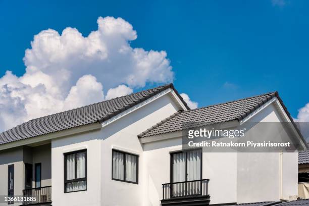 slate roof against blue sky, gray tile roof of construction house with blue sky and cloud background. - roof tiles stock pictures, royalty-free photos & images