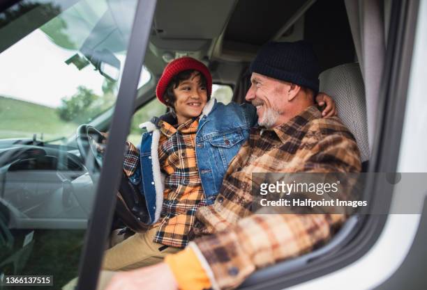 senior man with his grandson sitting in caravan in autumn day. - motorhome winter stock-fotos und bilder