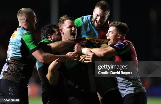 Alex Dombrandt of Harlequins is mobbed by team mates after scoring the last minute match winning try during the Heineken Champions Cup match between...