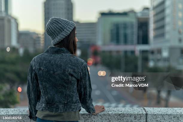 rearview shot of an unrecognizable young woman looking at the view from the top of a building outside - om zich heen kijken stockfoto's en -beelden