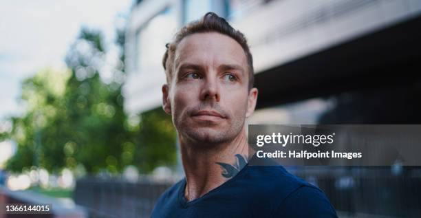 close-up of mid adult tattooed man walking in city. - handsome hunks stock pictures, royalty-free photos & images