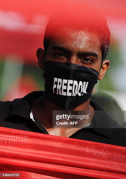 Sri Lanka's Marxist People Party supporter wears a scarf reading "Freedom" as he attends a demonstration demanding governemental actions to find...
