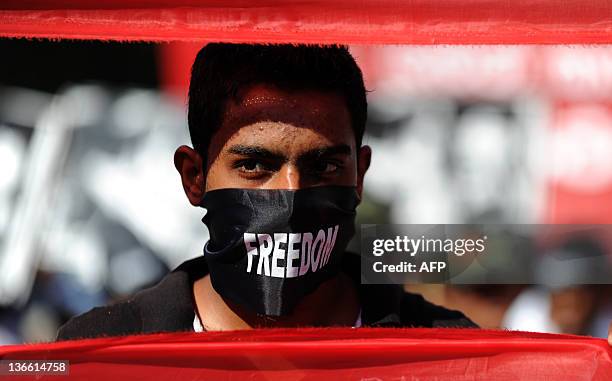 Sri Lanka's Marxist People Party supporter wears a scarf reading "Freedom" as he attends a demonstration demanding governemental actions to find...