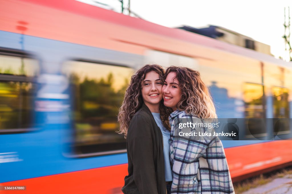 Friends Catching Train Portrait Of Two Young Female Friends At A Train Station Laughing And ...
