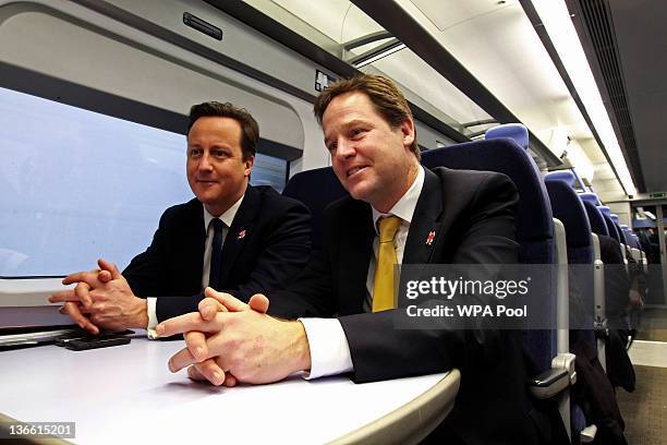 Britain's Prime Minister David Cameron and Deputy Prime Minister Nick Clegg ride a train to a cabinet meeting at the 2012 Olympic Games site on...