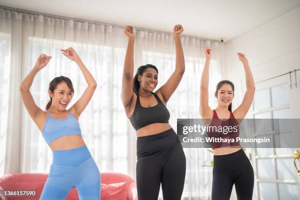 shot of a group of young women dancing together during a fitness class - fat woman dancing stockfoto's en -beelden