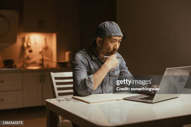 mid adult man working with laptop at table - laptop side view stock pictures, royalty-free photos & images