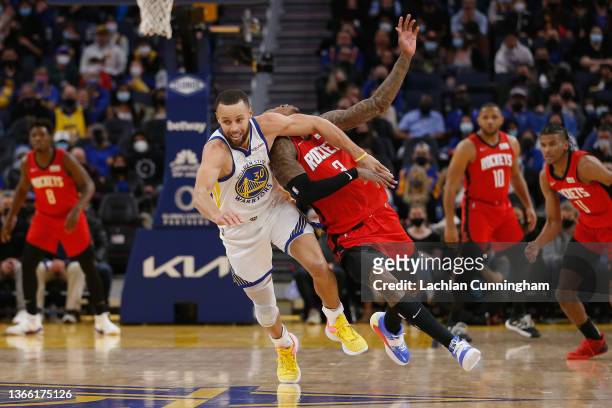 Stephen Curry of the Golden State Warriors gives away a loose ball foul on Kevin Porter Jr. #3 of the Houston Rockets in the first half at Chase...