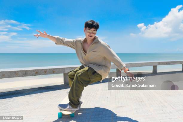 asian men  skateboarding outdoors on beautiful summer day - street fashion asian stock pictures, royalty-free photos & images