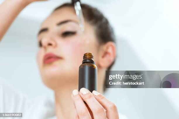 woman applying face serum - retinol stock pictures, royalty-free photos & images