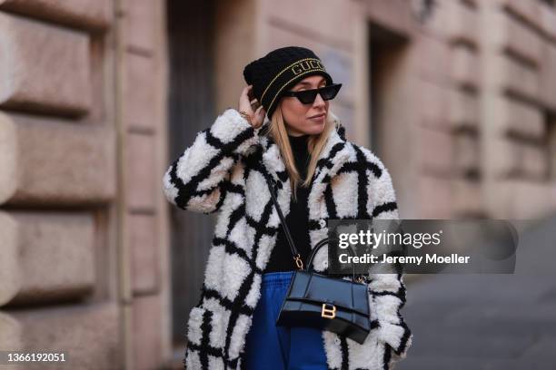 Sonia Lyson wearing Reformation black and white coat, Urban Outfitters blue joggingpants, Anine Bing black shades and Zara black turtleneck , on...