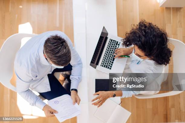 two business people  cooperating through the protective glass - business plan covid stock pictures, royalty-free photos & images