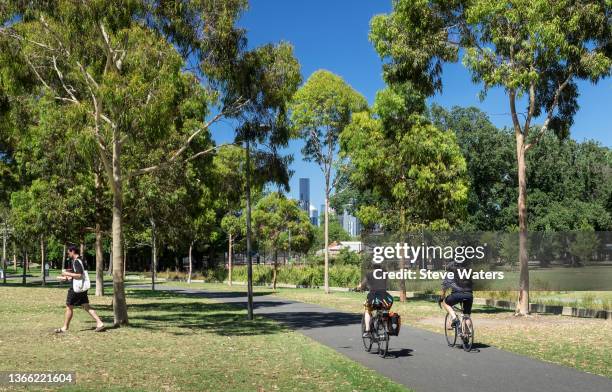 two cyclists in melbourne's edinburgh gardens. - bicycle lane stock pictures, royalty-free photos & images