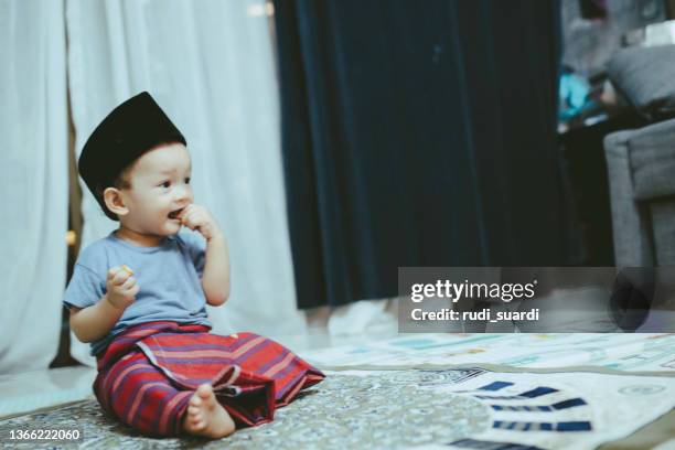 baby wearing a sarong and peci hat - malay songkok stock pictures, royalty-free photos & images