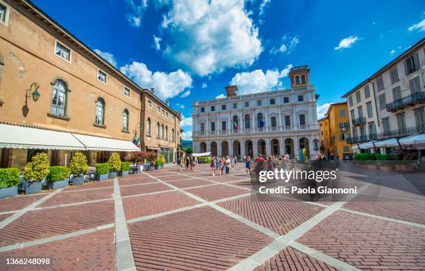 bergamo alta old square with tourists on a sunny day. - bergamo stock pictures, royalty-free photos & images