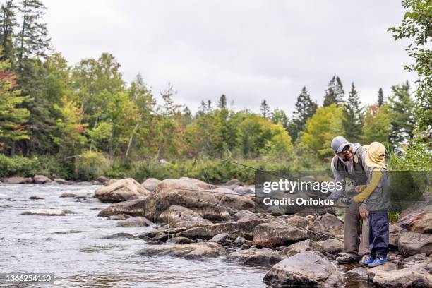 cute redhead boy and father fishing in the river in quebec - trout fishing stock pictures, royalty-free photos & images