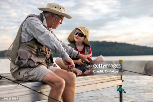 großvater und enkel angeln bei sonnenuntergang im sommer, quebec, kanada - old quebec stock-fotos und bilder