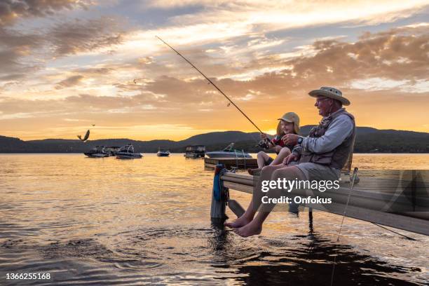 grandfather and grandson fishing at sunset in summer, quebec, canada - hobby bildbanksfoton och bilder