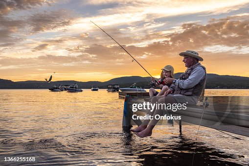 Grandfather and Grandson Fishing At Sunset in Summer, Quebec, Canada Grandfather and Grandson Fishing At Sunset in Summer, Quebec, Canada