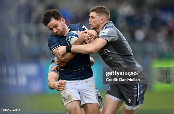 Hugo Keenan of Leinster is tackled by Tom Prydie and Ruaridh McConnochie of Bath during the Heineken Champions Cup match between Bath Rugby and...