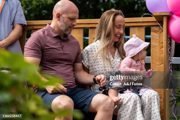 godparents holding their niece. - baptism girl stock pictures, royalty-free photos & images