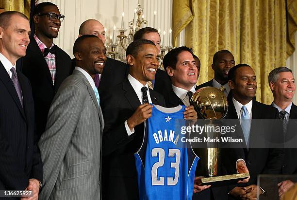 President Barack Obama is flanked by owner Mark Cuban and members of the Dallas Mavericks during an event to honor the NBA champions in the East Room...