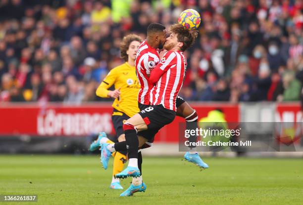 Mathias Jensen and Rico Henry of Brentford collide during the Premier League match between Brentford and Wolverhampton Wanderers at Brentford...