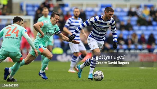 John Swift of Reading moves away from Jonathan Hogg during the Sky Bet Championship match between Reading and Huddersfield Town at the Madejski...