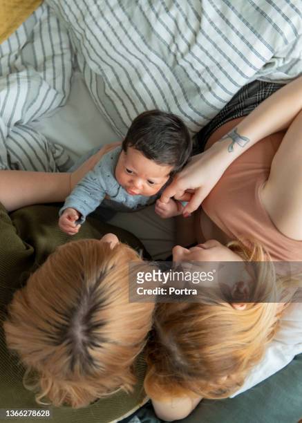 lesbian couple on bed with their baby boy - cute lesbian couples 個照片及圖片檔