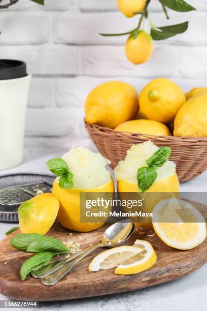 frozen lemon sorbet with basil served in lemon halves - sorbetto stock pictures, royalty-free photos & images