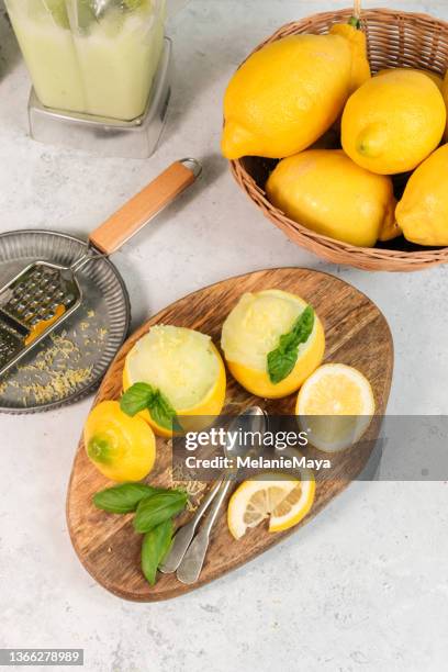 frozen lemon sorbet with basil served in lemon halves - sorbetto stock pictures, royalty-free photos & images