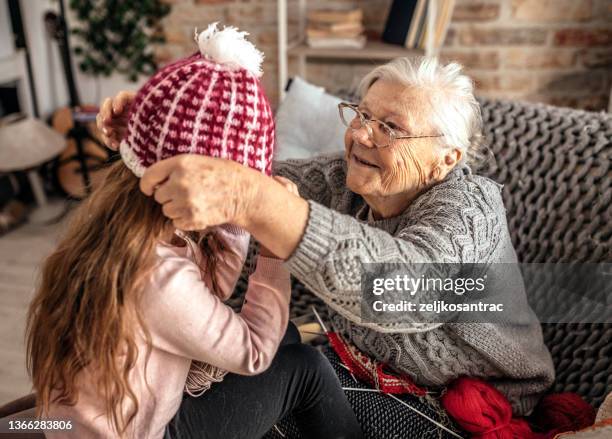 oma bringt enkelin das stricken mit nadeln bei - old granny knitting stock-fotos und bilder