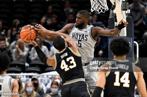 Timothy Ighoefe of the Georgetown Hoyas blocks a shot in the first half by Eric Dixon of the Villanova Wildcats at Capital One Arena on January 22,...