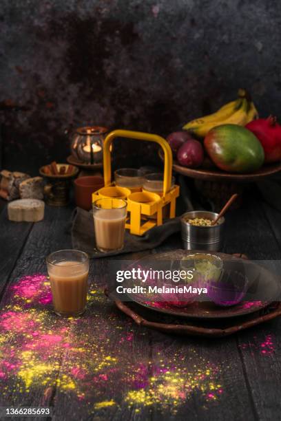 indian chai tea with colorful holi celebration powder in moody kitchen - chai tea stock pictures, royalty-free photos & images