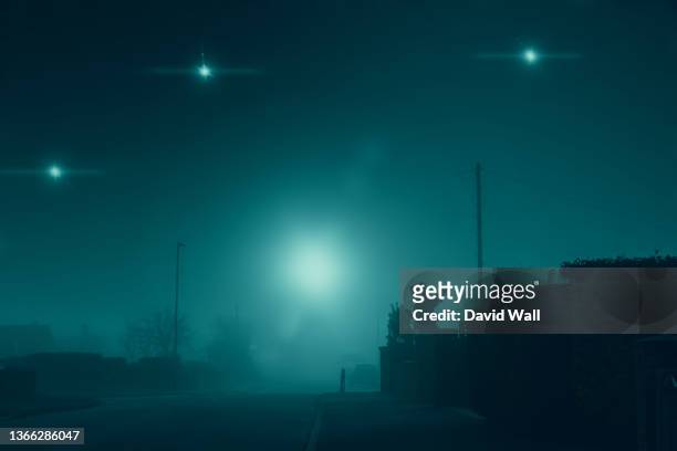 glowing ufo lights in the sky. in a quiet empty road in a suburban town. on a quiet, atmospheric foggy winters day. uk - flying saucer stock pictures, royalty-free photos & images