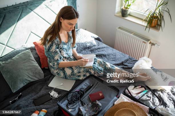 young woman doing her last check to be sure if she have everything she needs for vacation - s the adventures of rin tin tin stockfoto's en -beelden