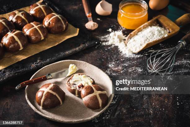 hausgemachte ostern hot kreuz brötchen mit butter mit backwerkzeugen und mehl - hot cross buns stock-fotos und bilder