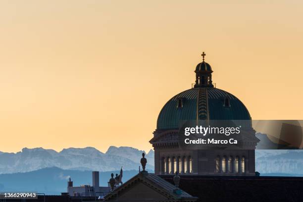 die kuppel des bundeshauses und die alpen bei sonnenaufgang - bern switzerland stock-fotos und bilder