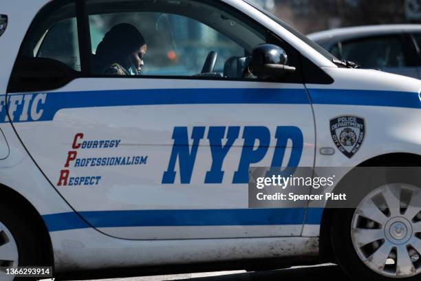 Police officer sits in her car in Harlem where two New York City police officers were shot last night after responding to a domestic call on January...