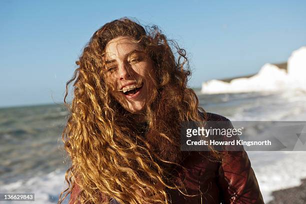 portrait of female lahghing on a windswept beach - wavy hair stock pictures, royalty-free photos & images