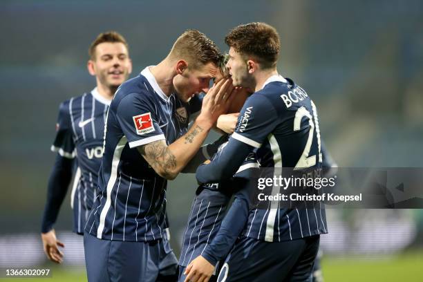 Takuma Asano of VfL Bochum celebrates with teammate Elvis Rexhbecaj and Sebastian Polter of Bochum after scoring their side's second goal during the...