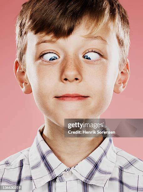 portrait of young boy with funny face - cross eyed 個照片及圖片檔